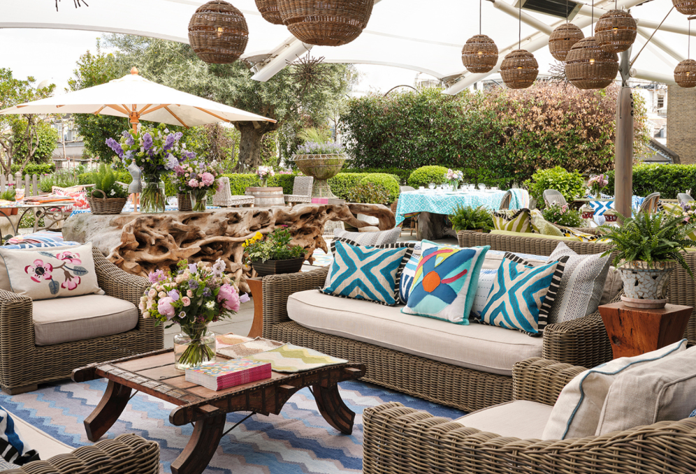 The roof terrace at Ham Yard Hotel featuring wicker furniture and lighting